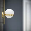 Applique murale en métal doré avec sphère en verre blanc décor cercle doré